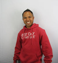 Thumbnail for medium-skinned person with short hair smiling wearing a red pullover hoodie with best day of my life written in white